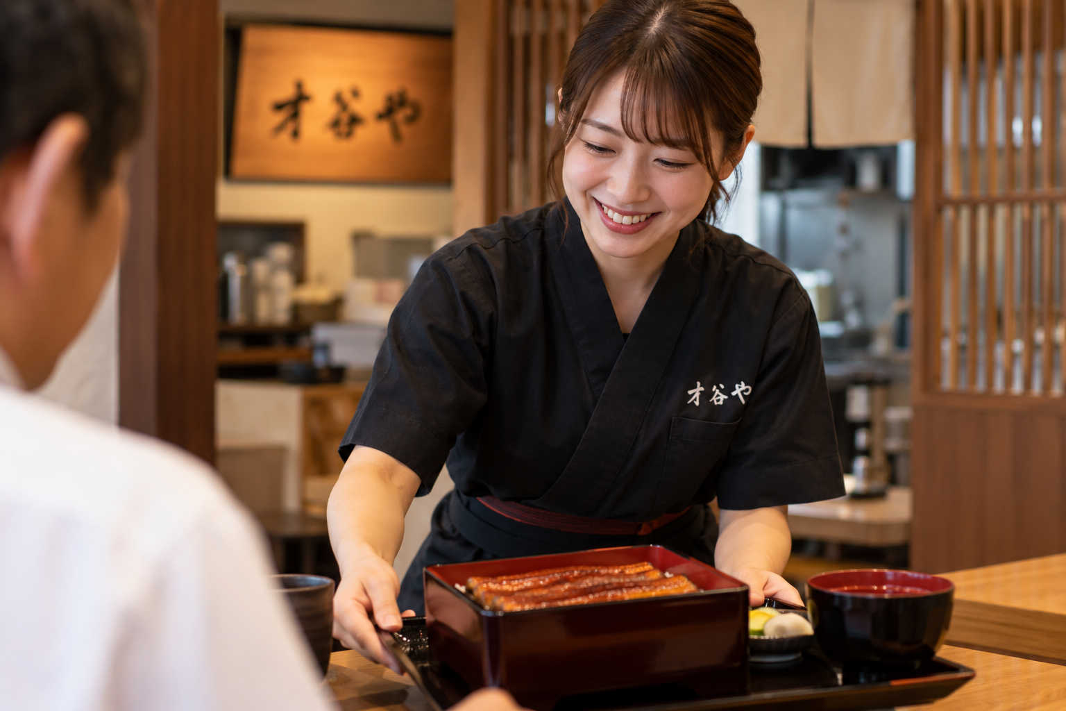 鰻重を配膳する女性のイメージ写真